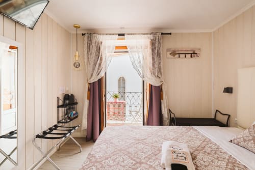Charme da Graça hotel bedroom in Lisbon with double bed, balcony view, and vintage-style decor