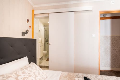 Charme da Graça hotel room in Lisbon with bed, sliding wardrobe doors, and ensuite bathroom