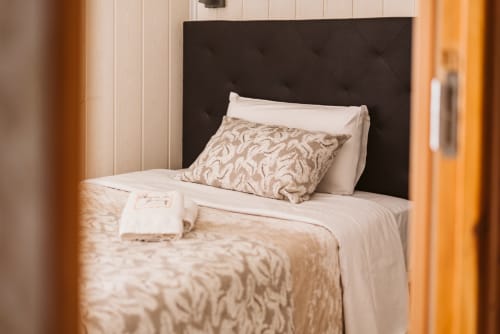 Cozy single bedroom at Charme da Graça hotel in Lisbon with quilted headboard and beige bedding