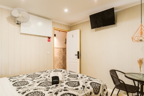 Charme da Graça hotel room 04 in Lisboa with queen bed, en-suite bathroom, TV, and work desk