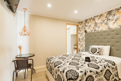 Charme da Graça hotel room in Lisbon with bed, patterned wallpaper, ensuite bathroom, pendant light and modern decor