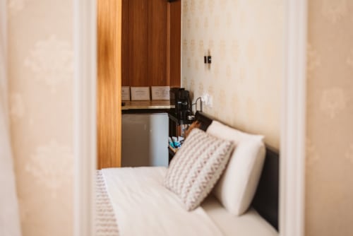 Cozy double bedroom at Charme da Graça hotel in Lisbon with bed, pillows, wooden wardrobe and in-room bathroom
