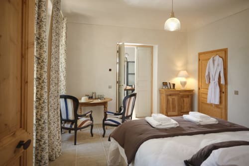 Chambre Mamie Chou à la Ferme Saint-Georges en Provence avec vue sur le jardin, mobilier en bois et literie blanche