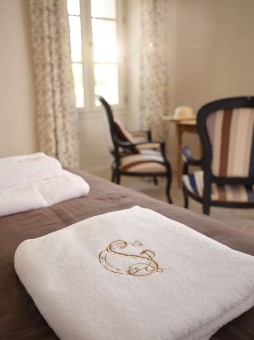 Chambre Provence à la Ferme Saint-Georges avec oreiller monogrammé, vue sur jardin, mobilier élégant et lumière naturelle