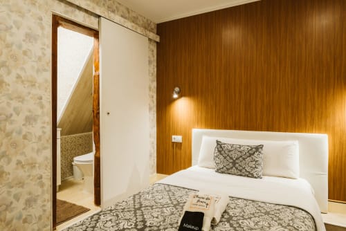 Charme da Graça hotel room 12 in Lisbon: compact bedroom with white bed, warm wood paneling, ensuite bathroom, and modern