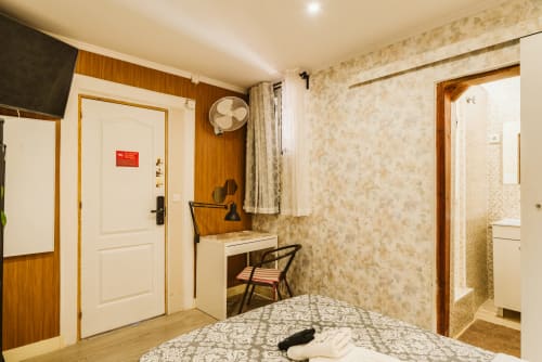 Cozy single room at Charme da Graça hotel in Lisbon with bed, desk, fan, and en-suite bathroom