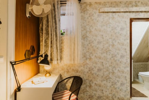 Cozy single room desk at Charme da Graça hotel in Lisbon with lamp, chair, and en-suite bathroom