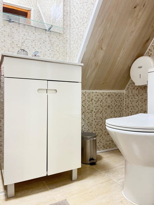 Modern bathroom at Charme da Graça hotel in Lisbon with white vanity, toilet, and mosaic tile accents