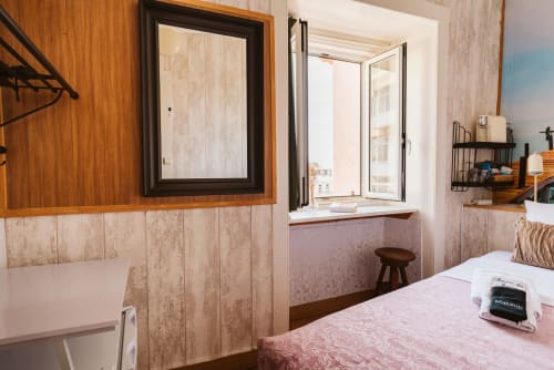 Small single bedroom at Charme da Graça, Lisbon, with wooden accents, window, and pink bedding