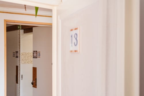Room 13 corridor at Charme da Graça hotel in Lisbon with wooden door frame and room number sign