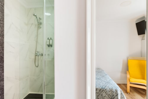 Modern ensuite shower with marble tiles in a double room at Charme da Graça hotel, Lisbon