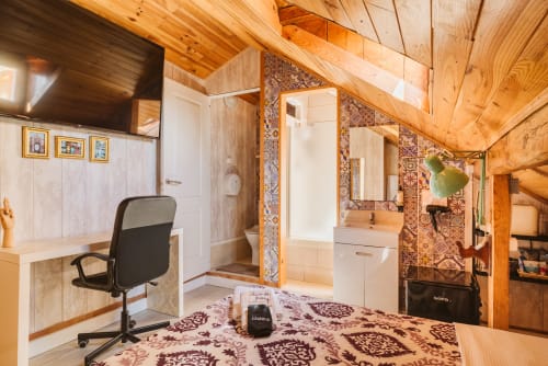 Cozy double room at Charme da Graça Lisboa with wooden beams, work desk, ensuite bathroom, and patterned carpet