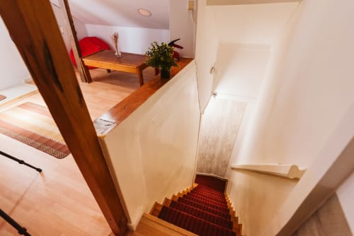 Staircase with red runner leading to attic room at Charme da Graça hotel, Lisbon