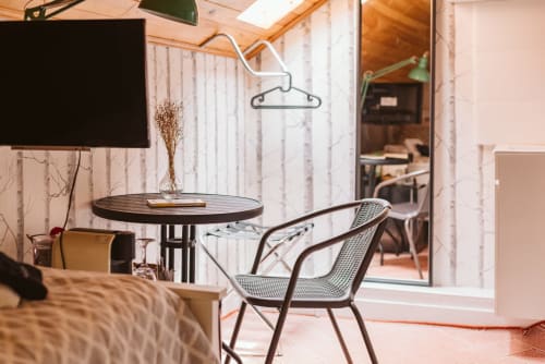 Single room at Charme da Graça hotel in Lisbon with modern chair, round table, and city view