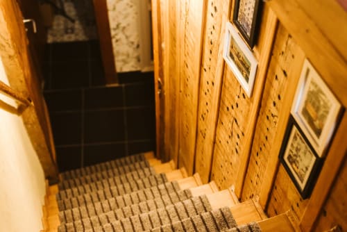 Narrow staircase at Charme da Graça hotel in Lisbon with wooden walls and framed artwork
