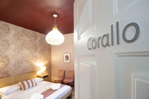 Camera Corallo dell'Epimoni B&B a Catania con arredamento moderno, lampada a sospensione e soffitto bordeaux