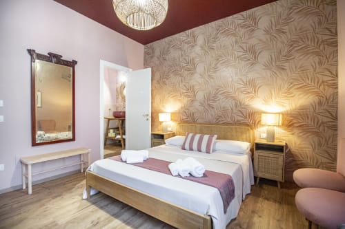 Camera doppia Corallo presso Epimoni B&B Catania con carta da parati tropicale, mobili in legno e vista sulla città