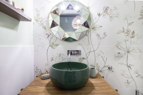 Bagno moderno dell'Epimoni B&B Catania con lavabo tondo verde scuro, specchio geometrico decorativo e dettagli botanici floreali