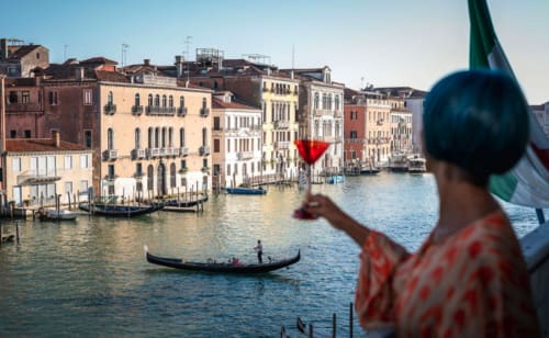 Ospite dell'hotel Ca Cortigiane che ammira il Canal Grande di Venezia con i suoi storici palazzi e la tradizionale gondola