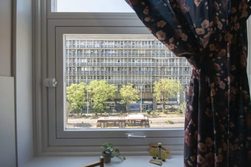 Vista dalla finestra della camera dell'hotel Epimoni a Catania: strada della città, alberi e facciata di edificio storico