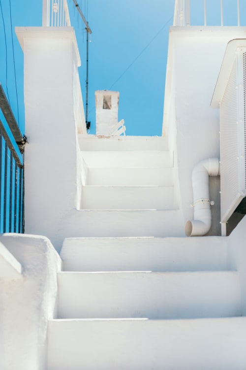 Terrazza sul tetto imbiancata a calce con gradini a Pietra & Luce a Ostuni, Italia, cielo azzurro e dettagli architettonici