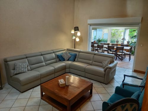 Salon avec grand canapé et fauteuils donnant sur l'espace repas