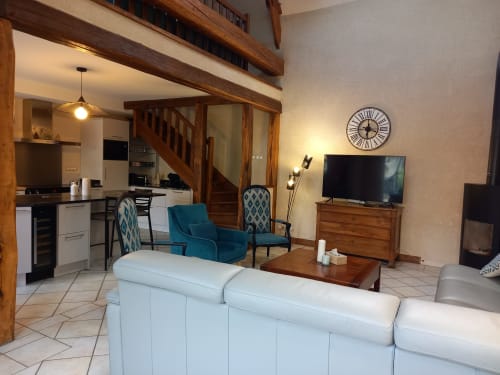 Salon avec canapé, TV et poêle à bois
