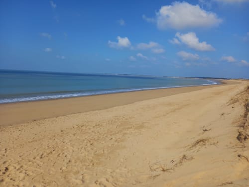 Plage de sable blanc, eaux turquoise et ciel nuageux près des Relais-Orbigny à L'Aiguillon-la-Presqu'île, France