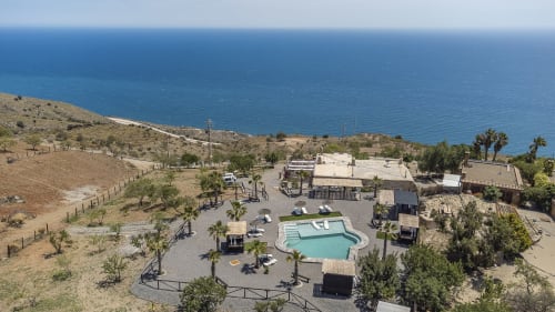 Vista aérea de la villa Paraje la Suerte en Adra con piscina, palmeras y vistas al mar Mediterráneo