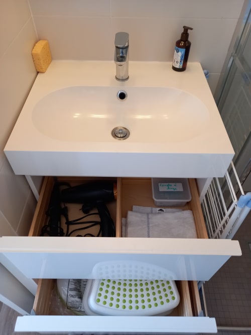 Lavabo blanc avec robinetterie chromée et distributeur de savon dans l'appartement Les Relais-Orbigny, tiroirs de rangement en dessous