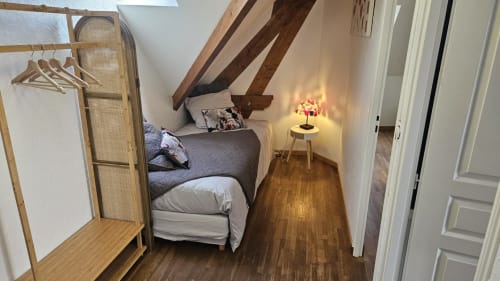 Coin nuit avec lit simple 90, paravent pour plus d'intimité et portant à vêtements.