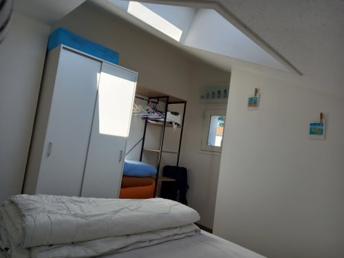 Chambre lumineuse aux Relais-Orbigny avec literie blanche, armoire, lit superposé et verrière à L'Aiguillon-la-Presqu'île