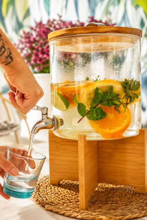 Ospite che versa acqua aromatizzata con agrumi e menta al Villa Bina Sea Hotel di Serrara Fontana