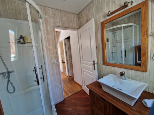Salle de bain étage avec douche et toilettes.