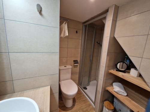 Salle de bain du studio avec douche et toilettes.