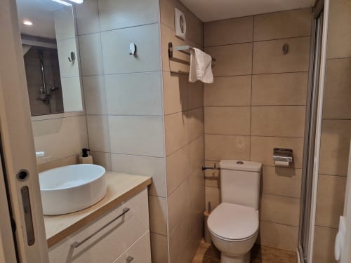 Salle de bain du studio avec douche et toilettes.