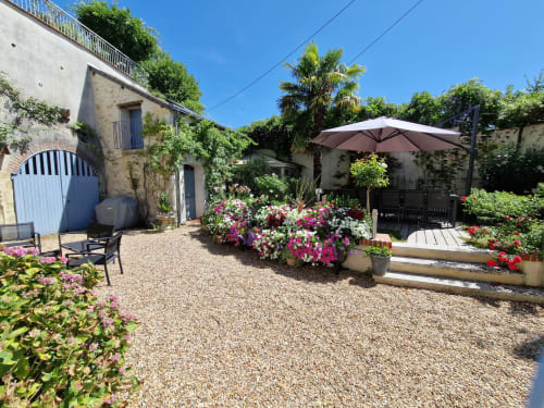 Jardin charmant de la villa aux Villas Amboise Guadeloupe avec plantes fleuries, salon ombragé et cour en pierre