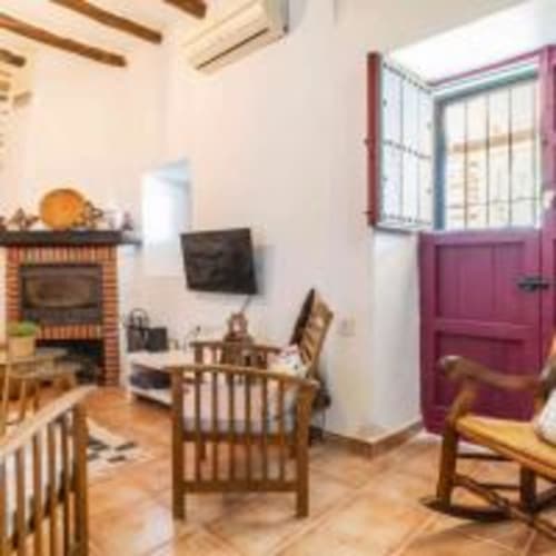 Interior de villa rústica en Paraje la Suerte, Adra con chimenea, muebles de madera y puerta morada