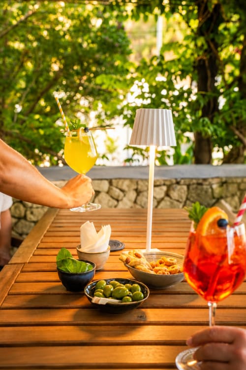 Cena all'aperto a Villa Bina Sea Hotel con aperitivi, cocktail e stuzzichini mediterranei sotto gli alberi rigogliosi
