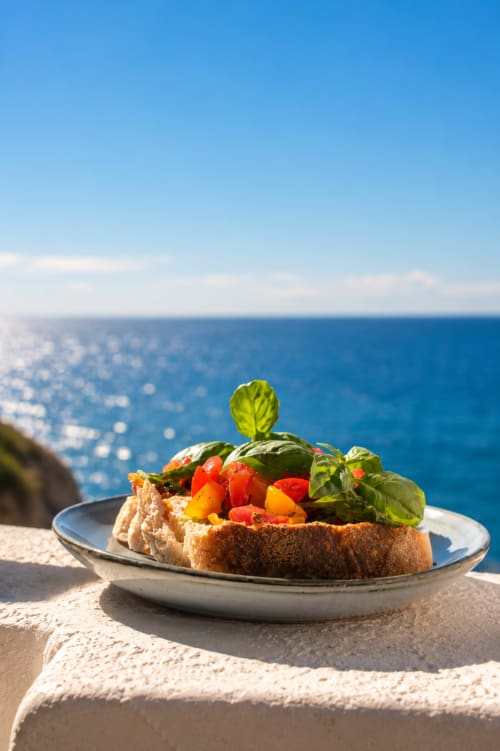 Bruschetta con pomodori freschi e basilico con vista sul Mar Mediterraneo presso Villa Bina Sea Hotel
