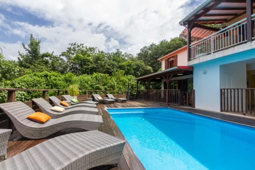 Terrasse en bois avec piscine et transats.
