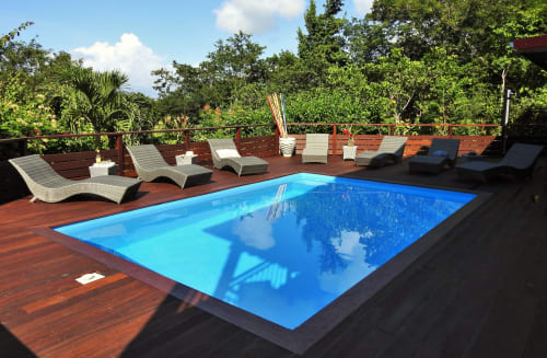 Terrasse en bois avec piscine et transats. 