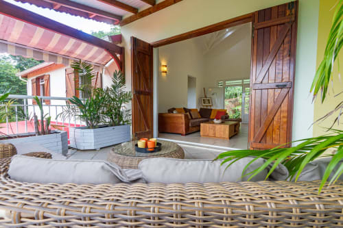 A l'étage, grande terrasse avec coin salon . Vue sur l'intérieur de la villa et le grand salon/tv.