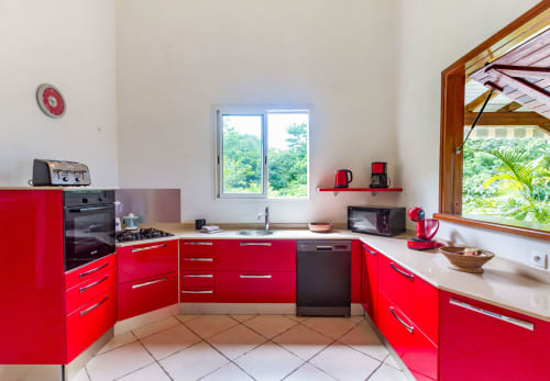 Cuisine rouge moderne avec plaque de cuisson à gaz , four, four micro-ondes, lave vaisselle, grille pain, bouilloire, cafetiere fitre et cafetière Dolce Gusto.
