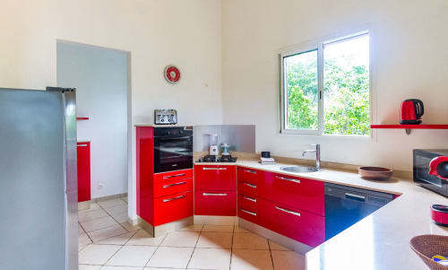 Cuisine moderne rouge équipée avec frigo américain .
