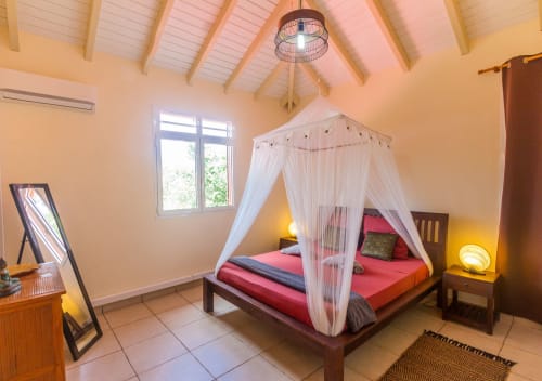 Chambre parentale climatisée à l'étage de la villa, avec lit 160, moustiquaire, salle de bain attenante et rangements.