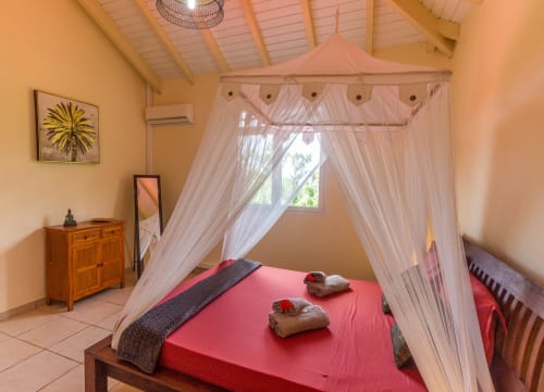 Chambre parentale climatisée à l'étage de la villa, avec lit 160, moustiquaire, salle de bain attenante et rangements.