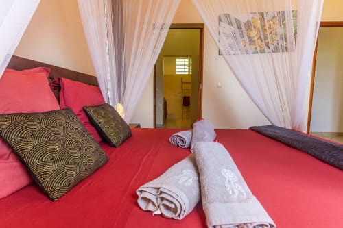 Chambre parentale climatisée à l'étage de la villa, avec lit 160, moustiquaire, salle de bain attenante et rangements.