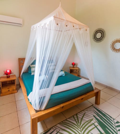 Spacious, air-conditioned bedroom on the upper floor of the villa, with a 160-cm bed, mosquito net, and closet. 