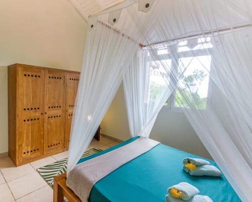 Grande chambre climatisée à l'étage de la villa, avec lit 160, moustiquaire, armoire de rangement.